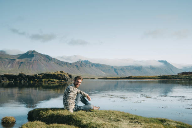 Man sitting on the beach in Iceland Young Caucasian man sitting on the beach in Iceland beautiful multi colored tranquil scene enjoyment stock pictures, royalty-free photos & images