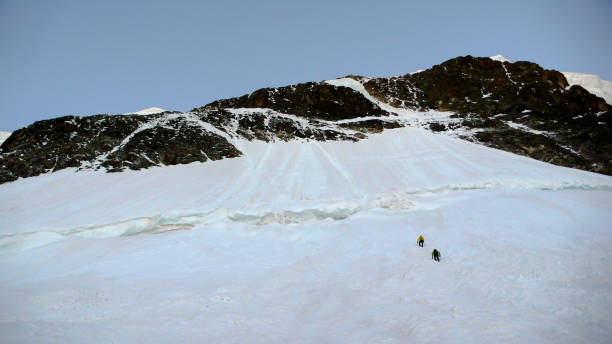 istock two mountain climbers approaching the north face of Piz Roseg 859248188