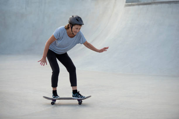 donna senior sportiva che pratica lo skateboarding. - skateboard park extreme sports recreational pursuit skateboarding foto e immagini stock