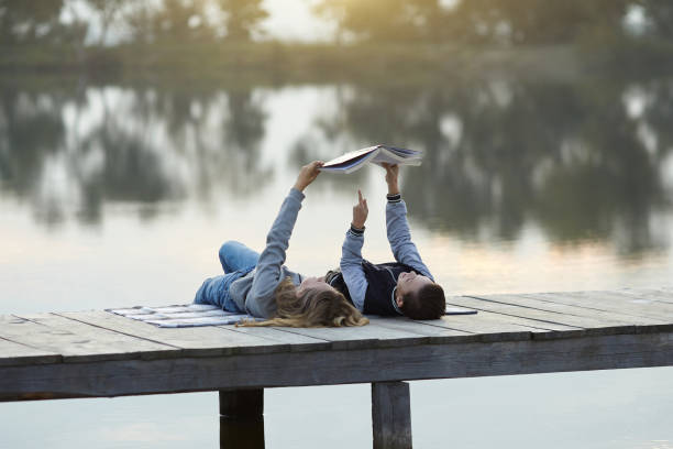 istock Children reading book on the lake 859254216