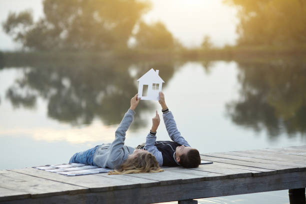 Happy couple of kids dream of a home Happy couple of kids dream of a home. House concept bridge hand stock pictures, royalty-free photos & images