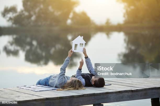 Happy Couple Of Kids Dream Of A Home Stock Photo - Download Image Now - House, Dreamlike, Lake