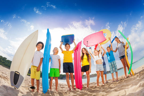 istock Many kids with mattresses surf boards on the beach 859255284
