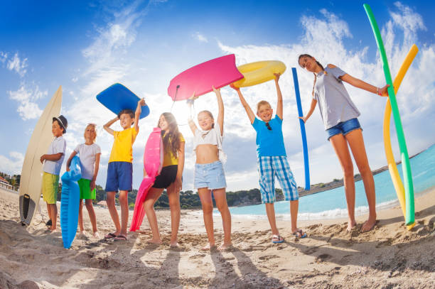 istock Many kids on a beach with swimming tools and toys 859255550