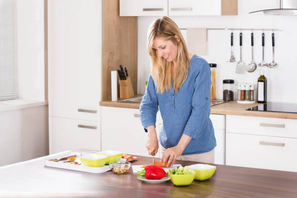istock Woman Cutting Vegetable On Chopping Board 859255640