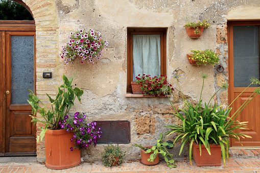 old house decorated with flower pots in Tuscany, Italy