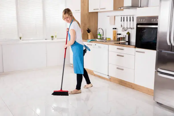 Photo of Housemaid Sweeping Floor In Kitchen