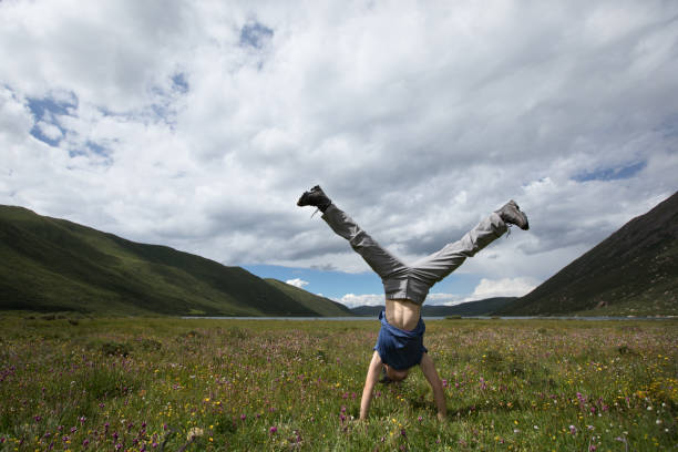 istock woman doing a handstand on mountain meadow 859262598