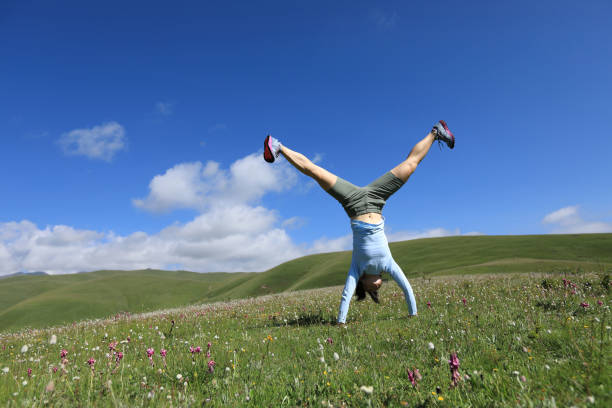istock handstand woman have fun in a mountain peak meadow 859265178