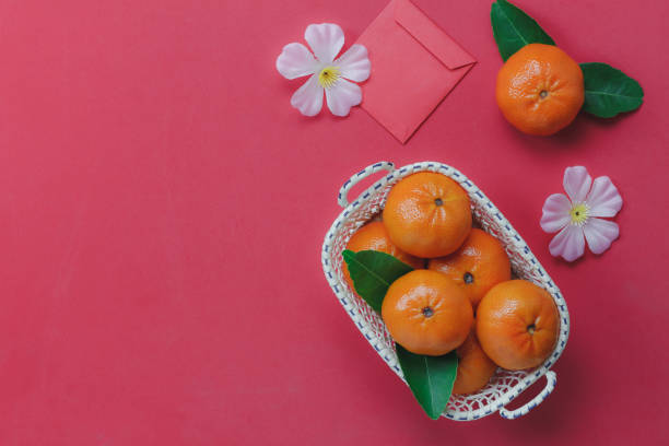 istock Top view of items for Chinese & Lunar Happy New Year background.Different.essential accessory on red wallpaper.oranges in the wood basket with flower and envelop.copy free space for creative design. 859270230