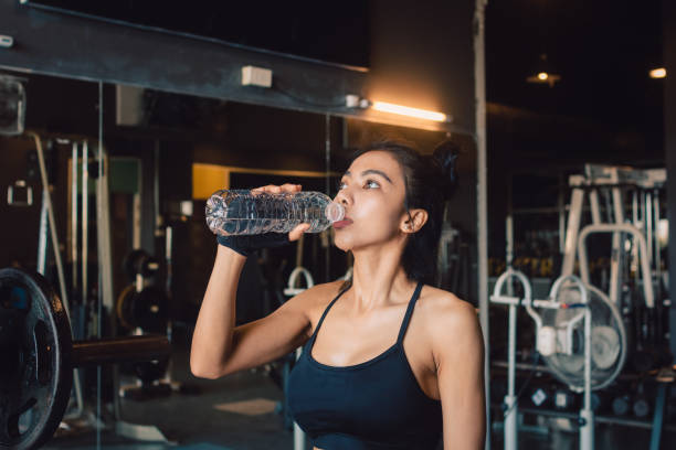 eau potable de jeune femme asiatique avec une rafraîchissante pendant l’entraînement au gymnase. - aerobics beautiful bottle body photos et images de collection