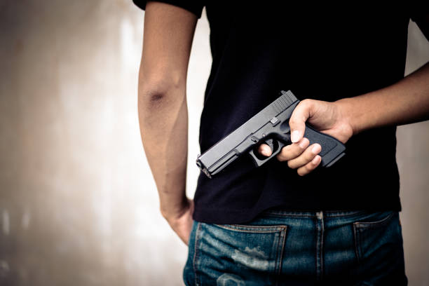 istock Robber hide gun in his back. Criminal and murder concept. Cross processing and split tone pinterest and instragram like process. Back view 859278350