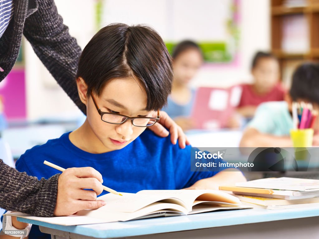 asiatische Schüler Hilfe von Lehrer in der Klasse - Lizenzfrei Lernender Stock-Foto