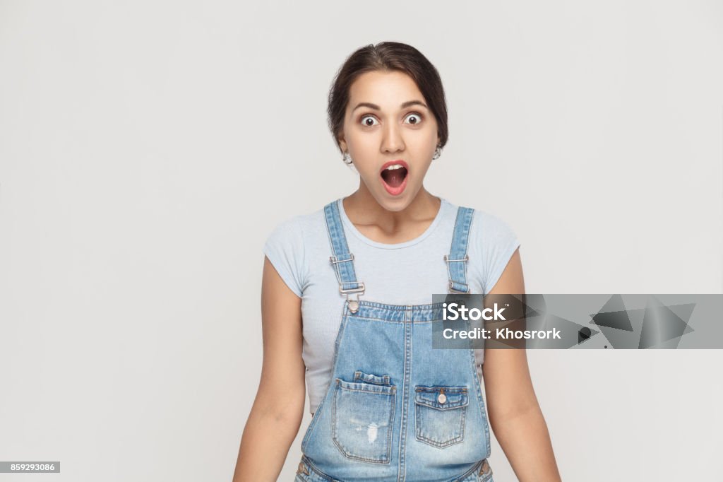 Wow! Portrait of  cute woman with shocked facial expression. Wow! Portrait of  cute woman with shocked facial expression. Studio shot, gray wall Women Stock Photo