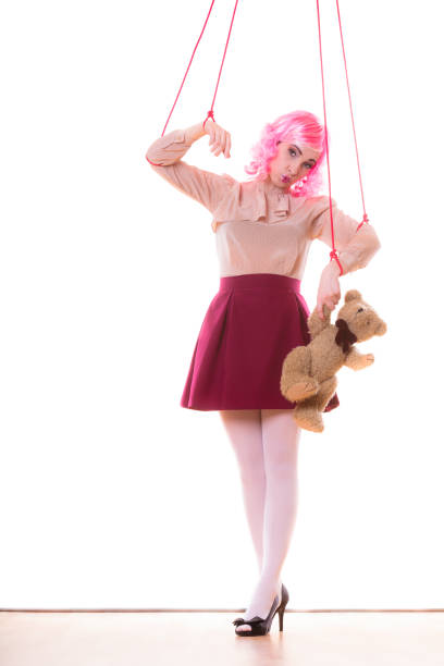 girl dressed as doll portrayed on black background