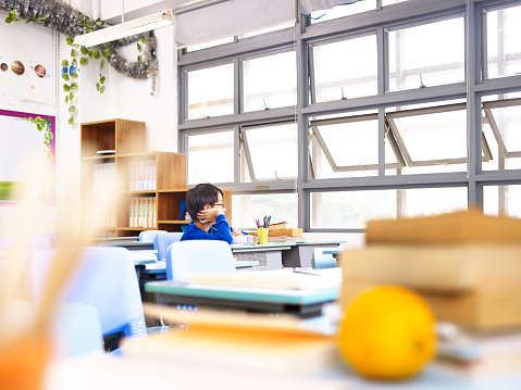 Escuela asiática estudiante sentado solo en el aula photo