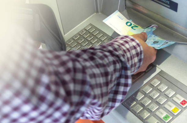 man using cash machine, taking euro in cash from atm stock photo