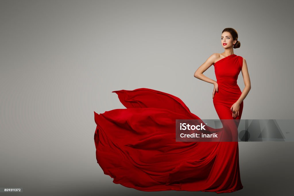 Fashion Model in Red Beauty Dress, Sexy Woman posing evening Gown, Flying Silk Tail Fashion Model in Red Beauty Dress, Sexy Woman posing evening Gown, Flying Silk Tail over gray background Red Stock Photo