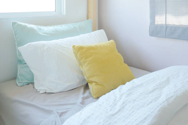 Yellow and green pillow on tiny bed in kid bedroom interior stock photo