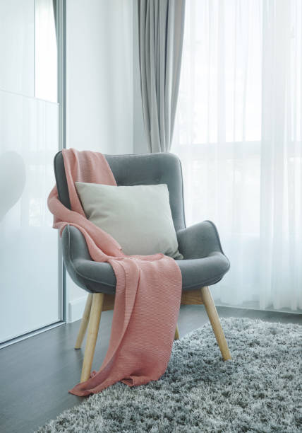 Pink scarf on dark gray vintage style armchair in the living room stock photo