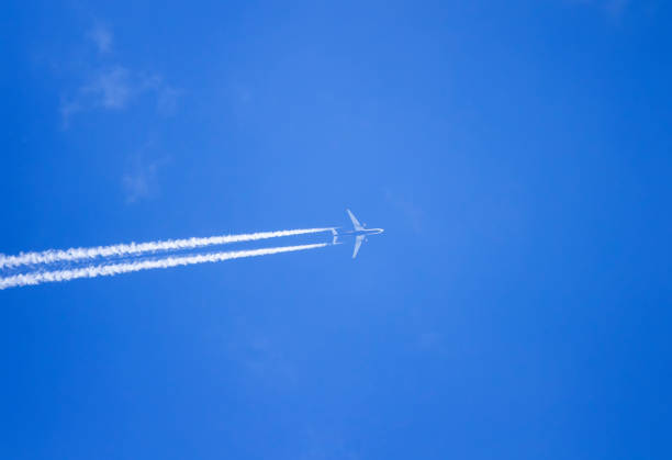 istock plane flying high in the blue sky and leaves a long white trail 859329096
