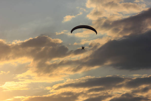 istock Silhouette of paraglider soaring  at sunset 859329558
