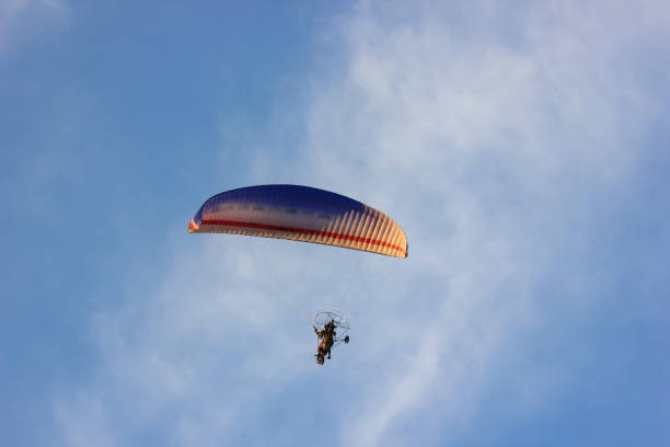 istock Silhouette of paraglider soaring  at sunset 859329566