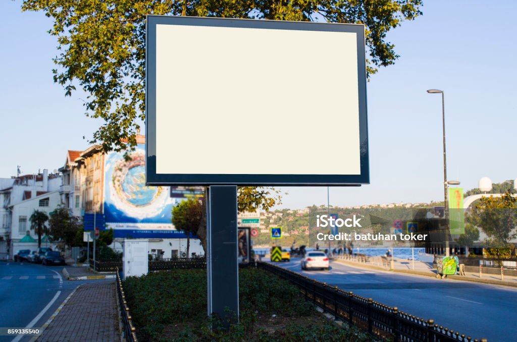 horizontal blank billboard on the city street in background buildings and road with cars mock up Billboard Stock Photo