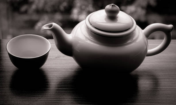 istock Teapot and empty cup on wooden table in garden 859335962