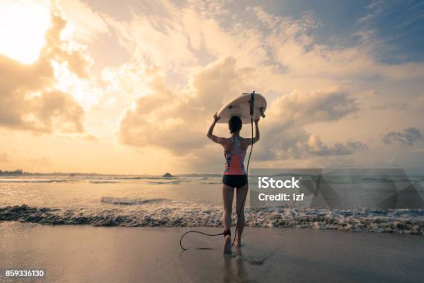 Rear View Of Young Woman Surfer With White Surfboard Walking To The Sea Stock Photo - Download Image Now