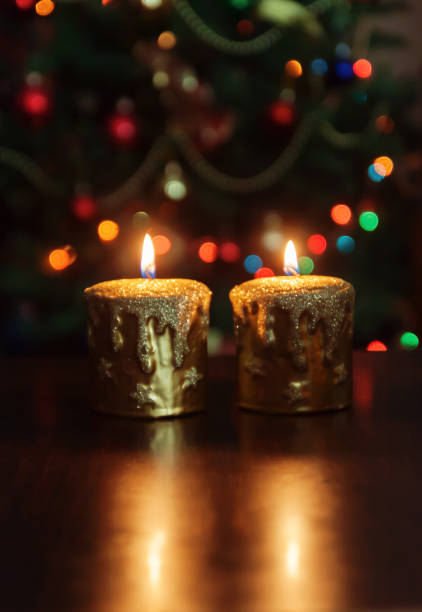 istock Christmas candle in front of a Christmas tree with sparkling lights and copy space. 859336614
