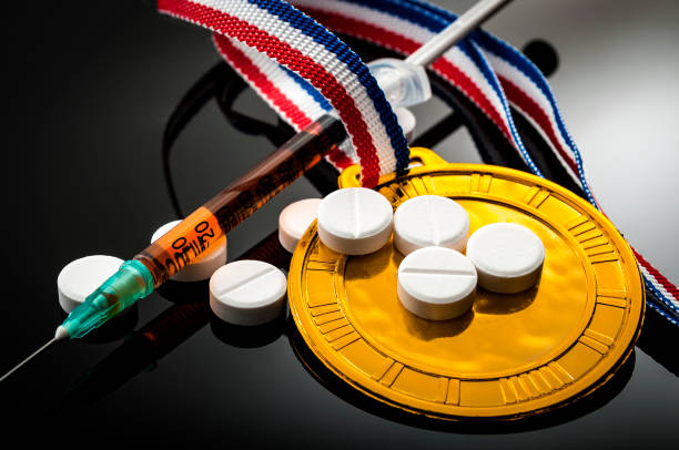 Doping in sports and steroid abuse concept Doping in sports and steroid abuse concept with a gold medal, prescription pills and a syringe on a dark background anti doping stock pictures, royalty-free photos & images