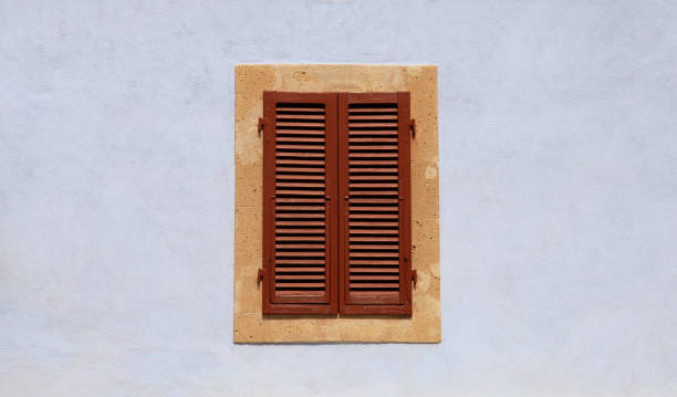 istock closed window with brown shutters on blue ancient wall 859348086