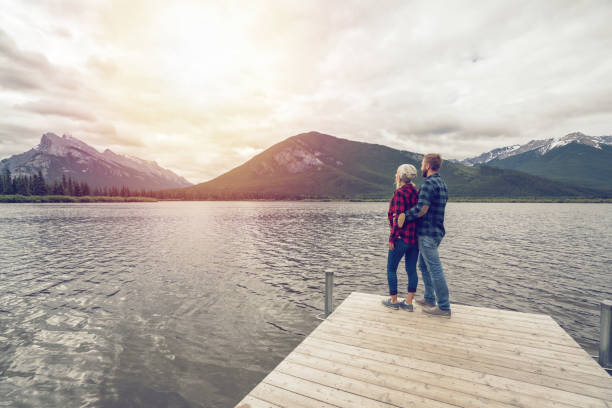 istock Young couple relaxing on lake pier 859348128