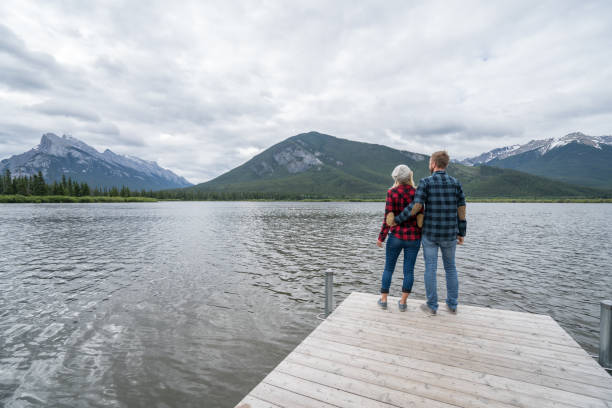 istock Young couple relaxing on lake pier 859350508