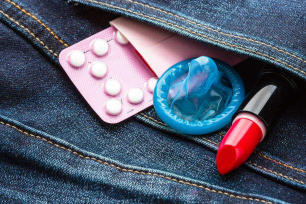 pilules préservatif et rouge à lèvres dans la poche de jeans. - sex condom jeans horizontal photos et images de collection