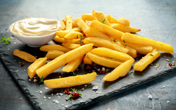 homemade baked potato fries with mayonnaise, salt, pepper on black stone board - turkey burger imagens e fotografias de stock