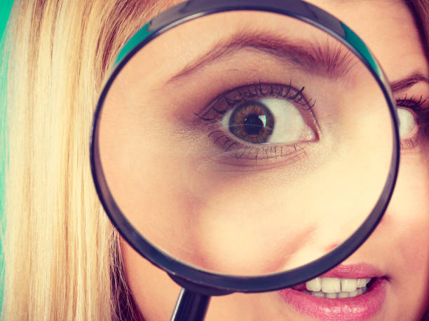 istock Woman looking through magnifying glass 859368404