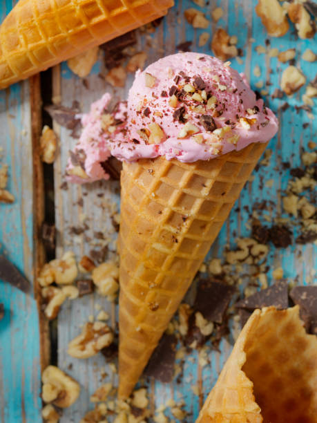 Strawberry Ice Cream With Chocolate and Nuts in a Waffle Cone
