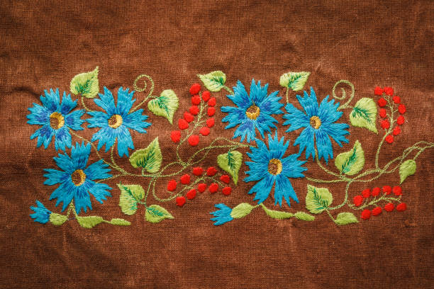 istock Floral ornament embroidered on brown fabric. 859375626