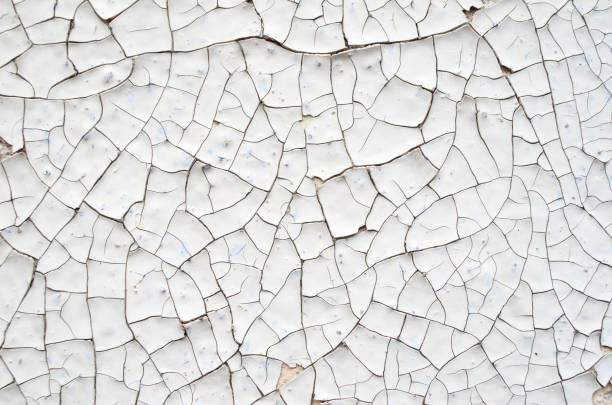 istock Cracked white and orange paint on a wall closeup 859382018