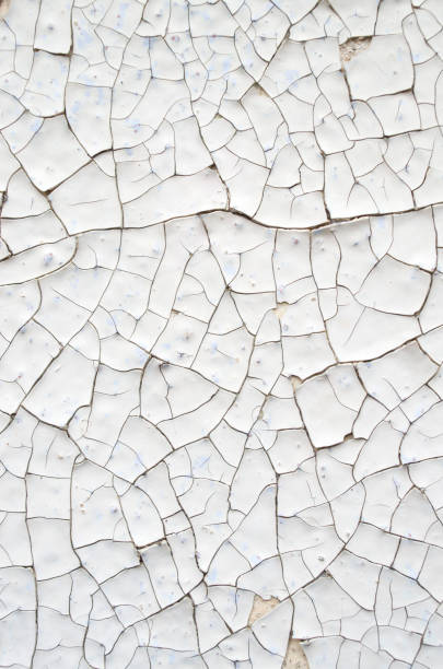 istock Cracked white and orange paint on a wall closeup 859382036