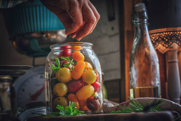 preservar orgánico mezclado color tomate cherry en los tarros - preserves pickle jar relish fotografías e imágenes de stock