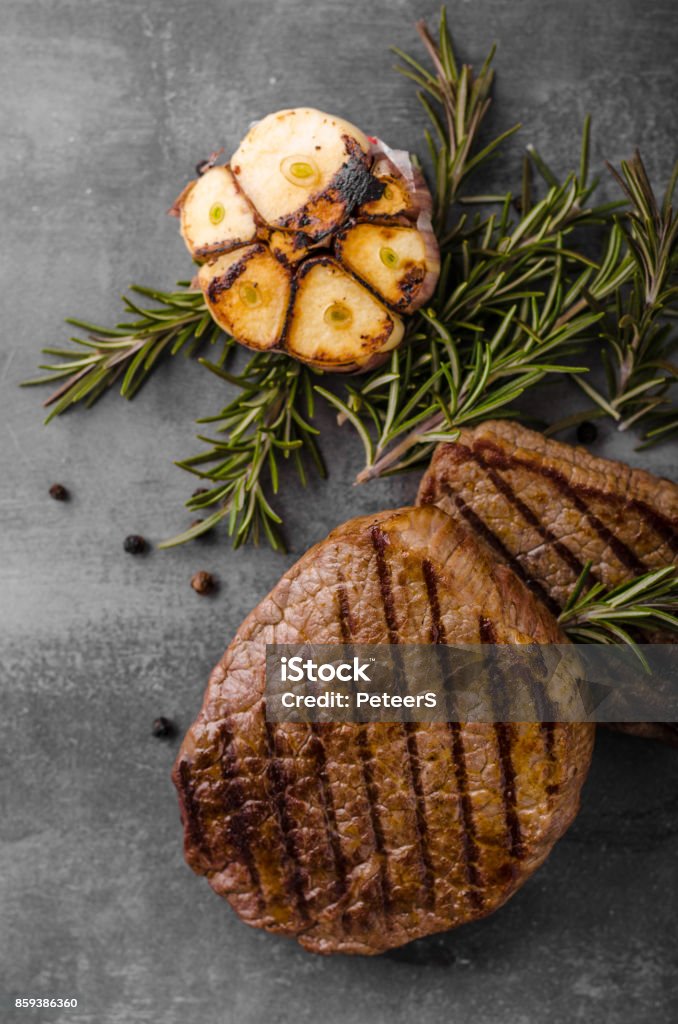 Steak with garlic, pepper and herbs Steak with garlic, pepper and herbs, place for advertisment, place for text Barbecue - Meal Stock Photo