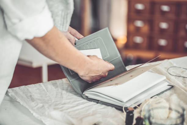 istock Businesswoman is puting a businesscard in a personal organizer 859392680
