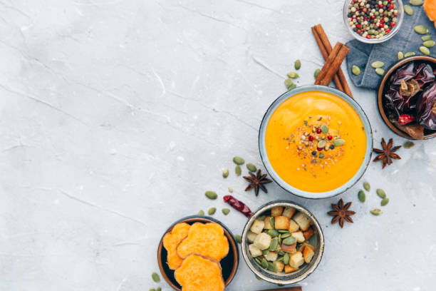 Bowl with fresh homemade carrot pumpkin soup and spices. stock photo