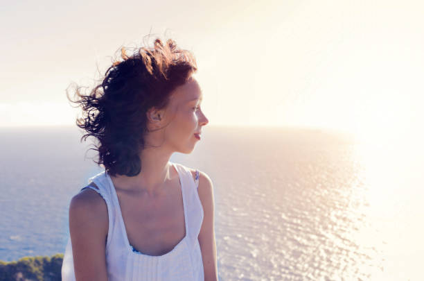 istock Girl watching sunset on the beach 859396568