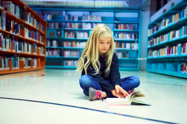 istock Child girl in library 859396720