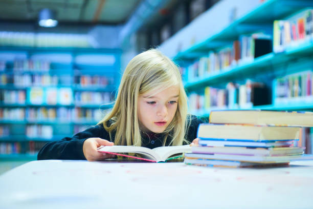 istock Child girl in library 859396848