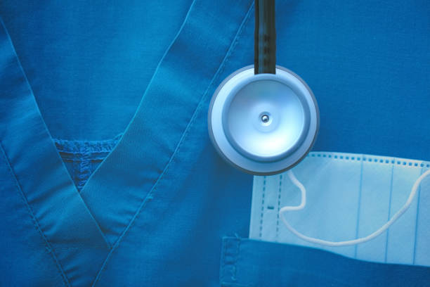 Fragment of medical work wear with protective mask and stethoscope Fragment of medical work wear with protective mask and stethoscope. medical scrubs stock pictures, royalty-free photos & images